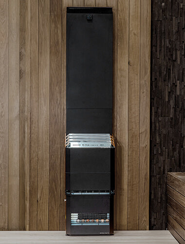 Tall black heater against a wooden wall