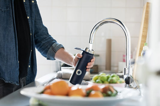 A person filling up their water bottle.