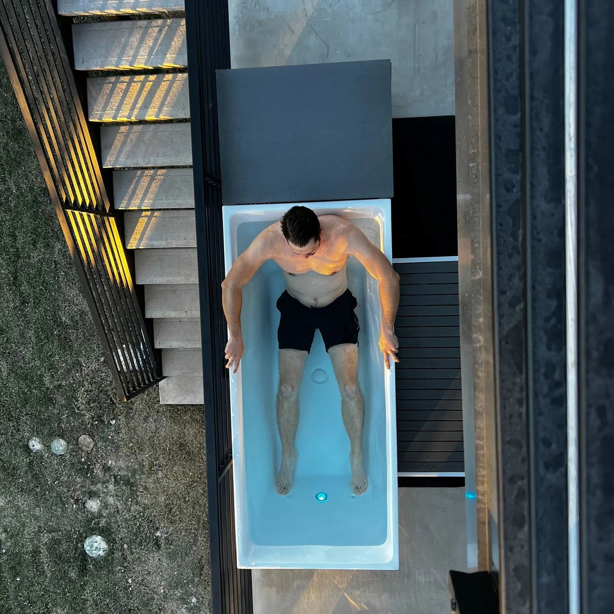Man in a bathtub with a modern outdoor setting