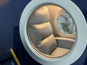 Close-up of an interior with a cushioned seat and reflective surface.