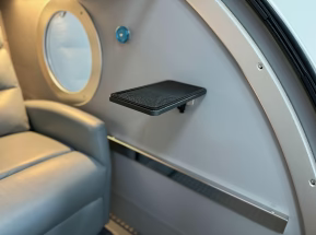Small table attached to an  Hyperbaric Chamber seat with a window view