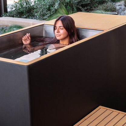 Woman relaxing in a modern hot tub with wooden exterior