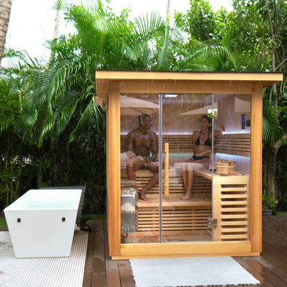 Two people in a wooden outdoor sauna surrounded by greenery