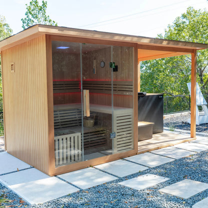 Wooden outdoor sauna with glass doors on a paved patio