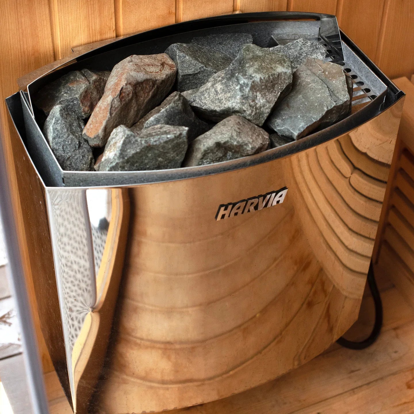 Harvia sauna stone grill with stones inside on a wooden background