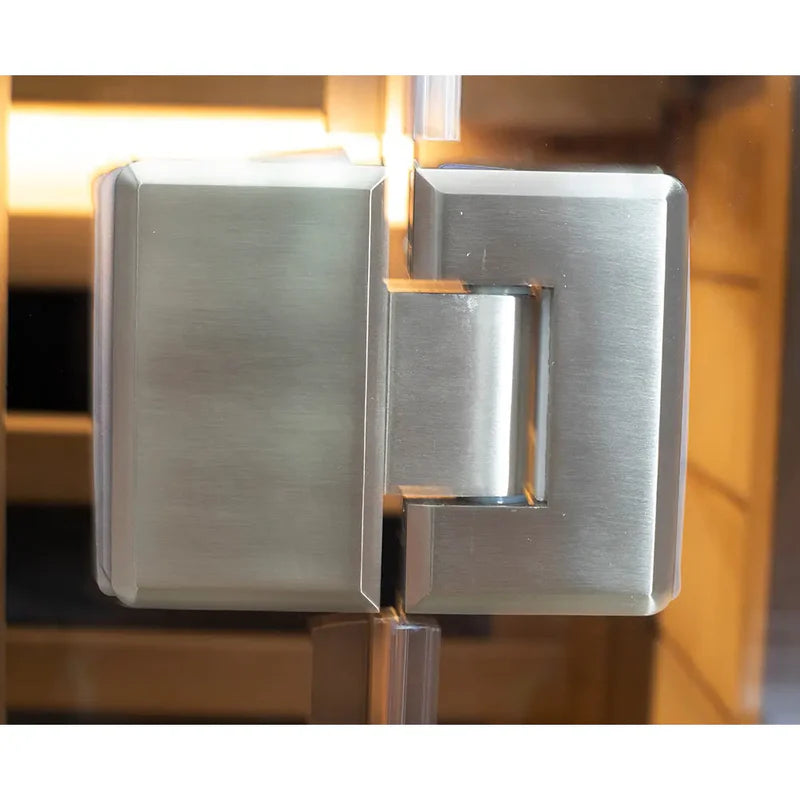 Metallic door handle on a glass door with a blurred background