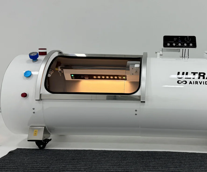 White hyperbaric chamber with 'Ultra Airvida' branding on a gray floor.