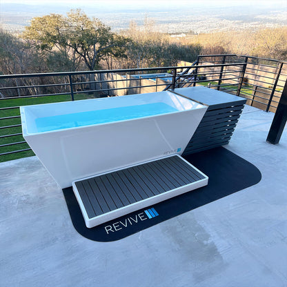 Outdoor cold tub with 'Revive' branding on a patio with scenic background