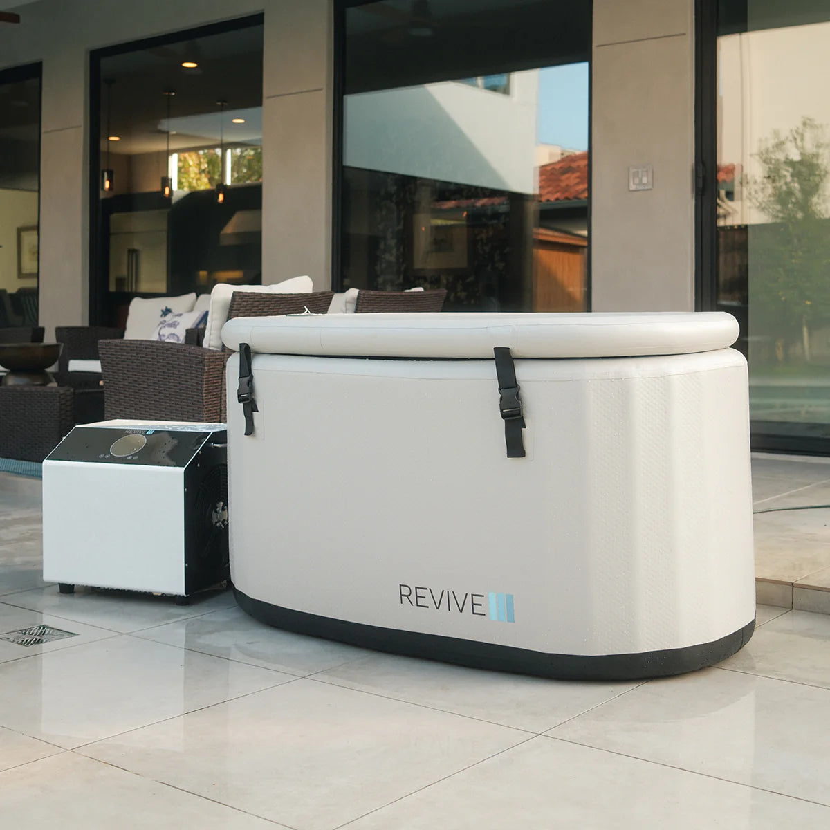 White 'REVIVE' cold tub in a modern indoor setting with large windows.