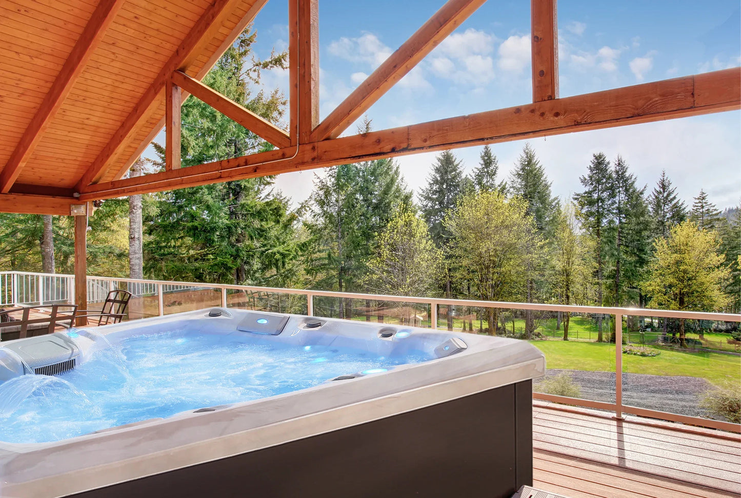 Hot tub on a deck with a view of trees and sky