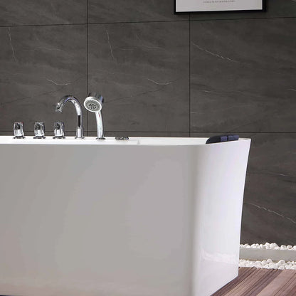 Modern white freestanding bathtub with chrome fixtures against a dark tiled wall.