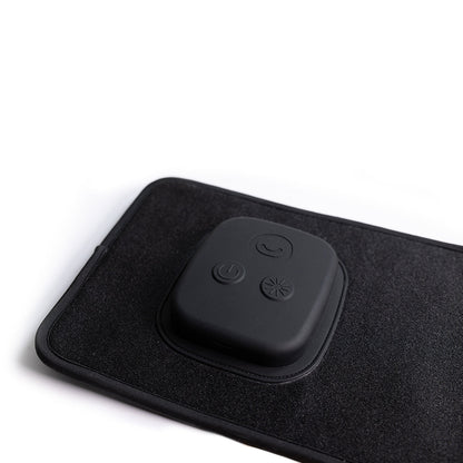 Black electronic device with buttons on a black mat against a white background