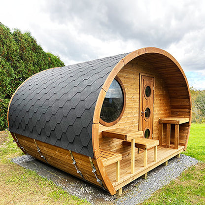 Wooden barrel-shaped cabin with a roof in an outdoor setting