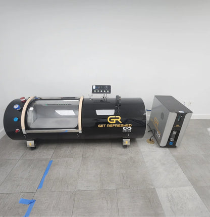 Black hyperbaric chamber with 'Get Refreshed Airvida' branding on a gray floor.