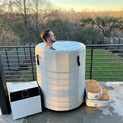 Person relaxing in a portable hot tub on a rooftop with a cityscape in the background