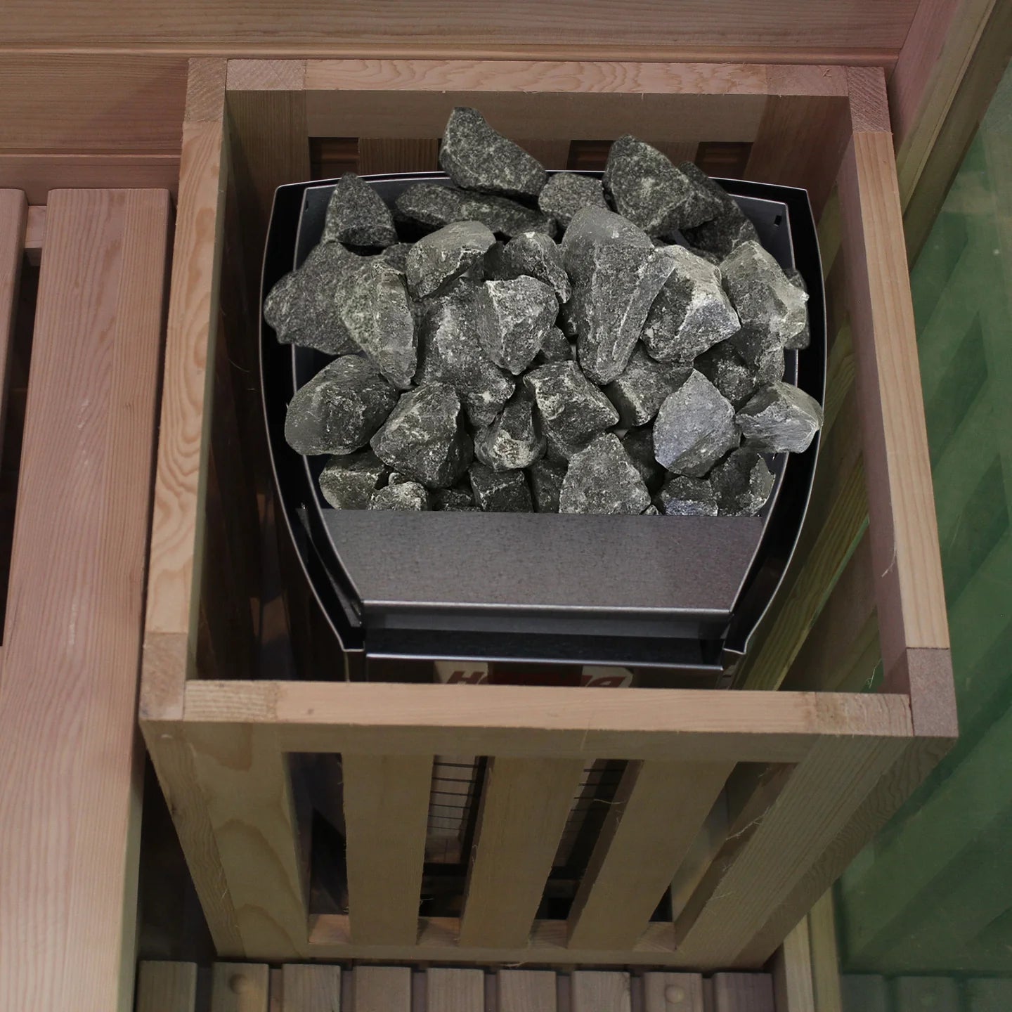Wooden box with steel heater with rocks inside on a wooden surface