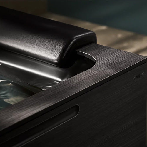 Close-up of a black leather headrest on a wooden surface with a blurred background