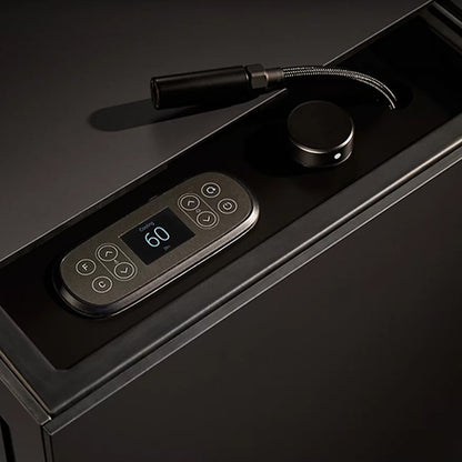Black temperature controler with digital display and keypad on a dark surface