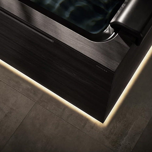Modern bathroom with a skylight and LED strip lighting on the floor.