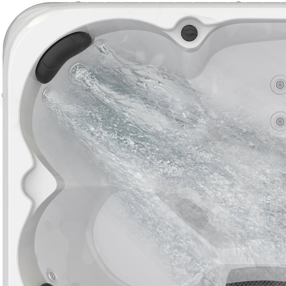 Hot tub with water flowing into it, showing the interior design and features.