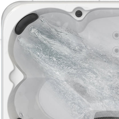 Hot tub with water flowing into it, showing the interior design and features.