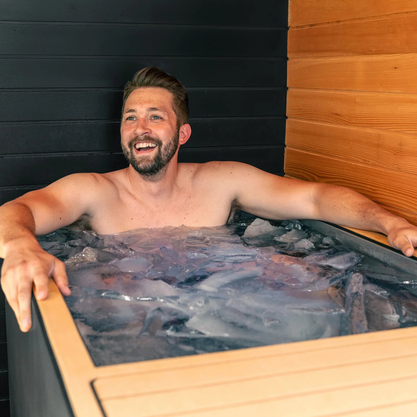 Man relaxing in a Cold tub  with wooden interior