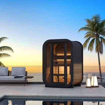 Outdoor sauna pod by a pool with palm trees and ocean view at sunset.