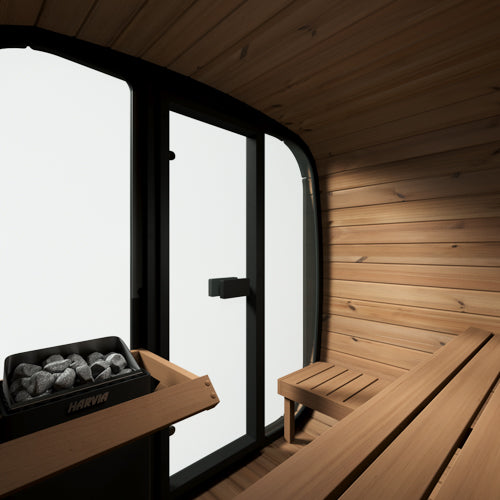 Wooden sauna interior with a bench and stone tray.