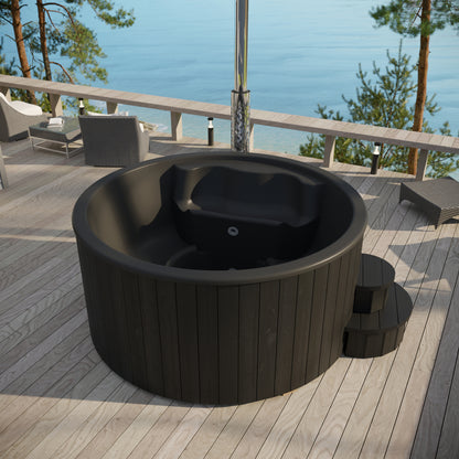 Black outdoor hot tub on a wooden deck with a scenic view of water and trees.