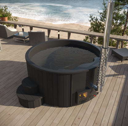 Black hot tub on a wooden deck by the ocean