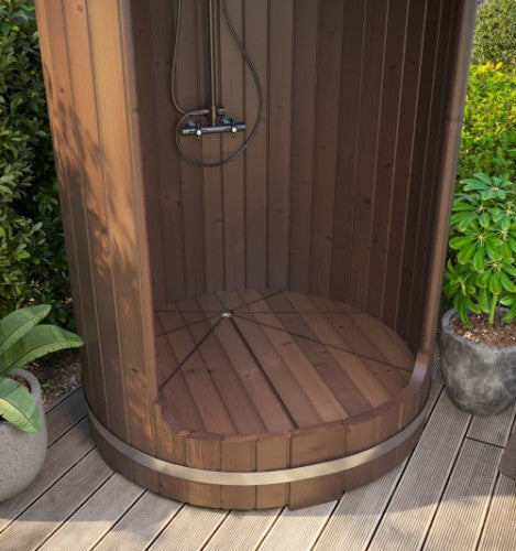 Wooden outdoor shower enclosure on a wooden deck with plants around.