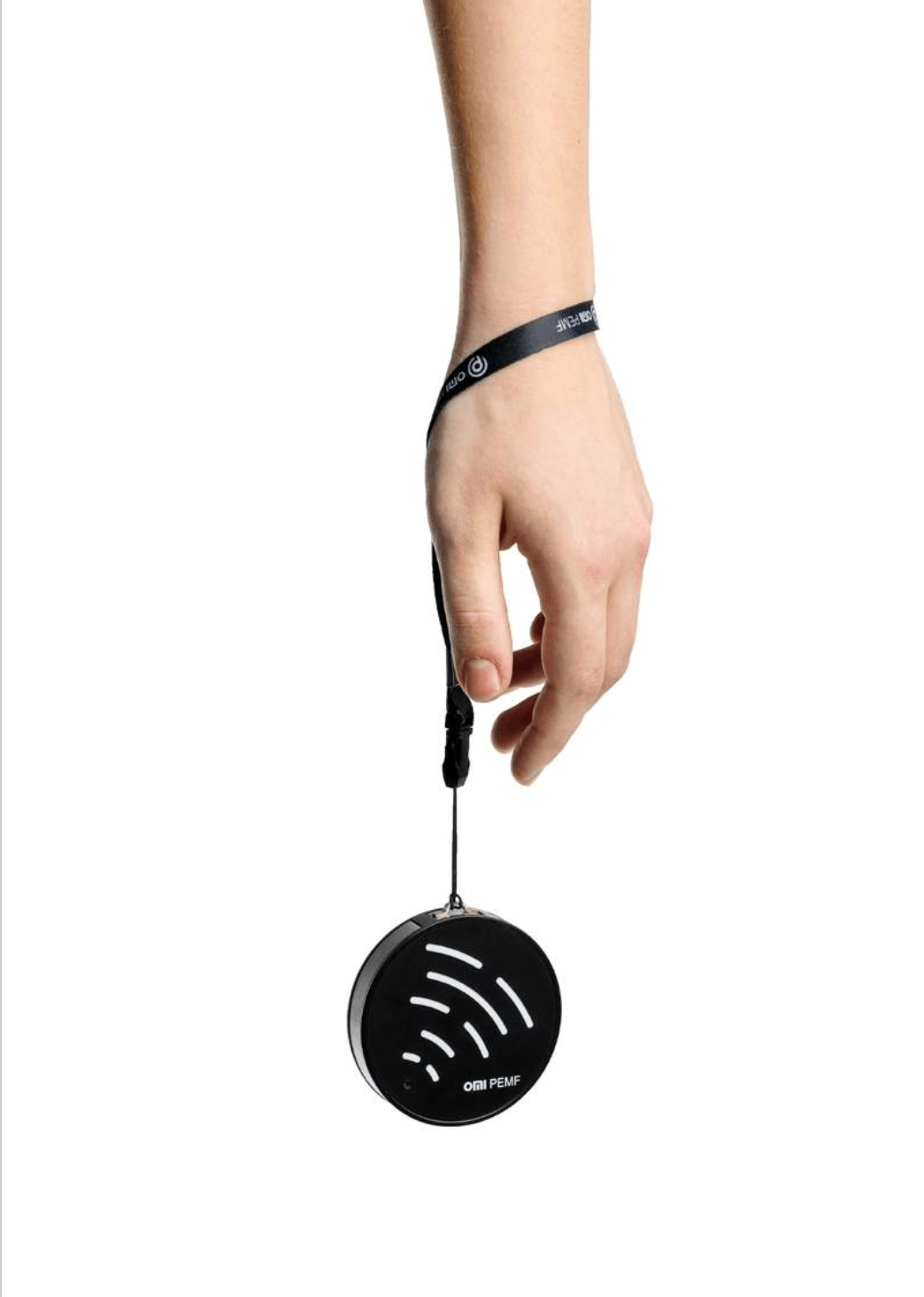 Hand holding a black circular pemf device with a strap on a white background