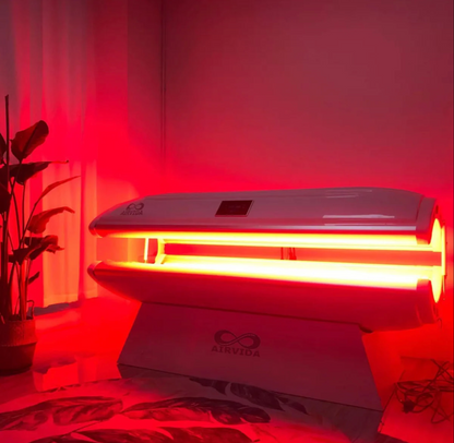 Red light therapy device with 'AIRVIVA' branding on a bed in a room.