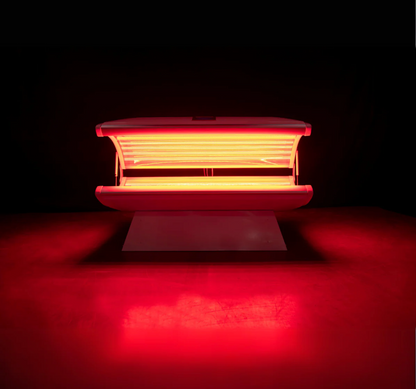 Red light therapy bed emitting a red light on a dark background