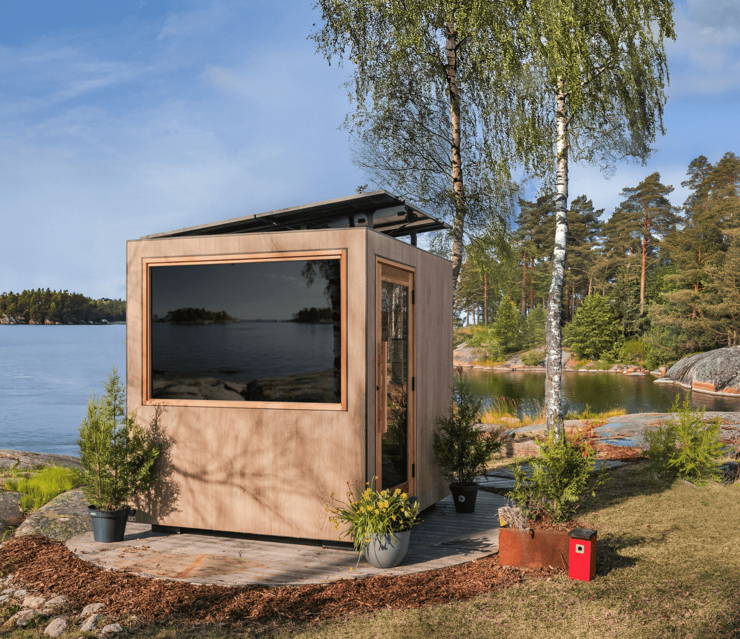 Modular sauna by a lake with trees and water in the background