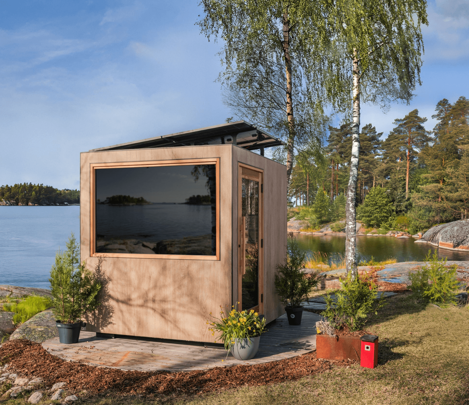 Modular sauna by a lake with trees and water in the background
