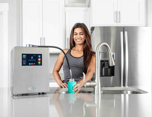 Woman using a water filtration system in a kitchen