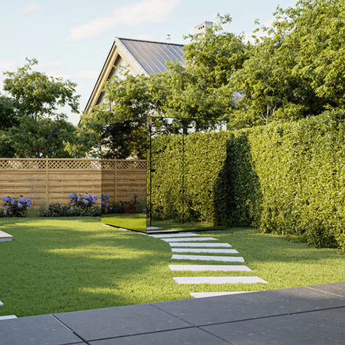 Garden with a pathway leading to a glass sauna, wooden fence and trees