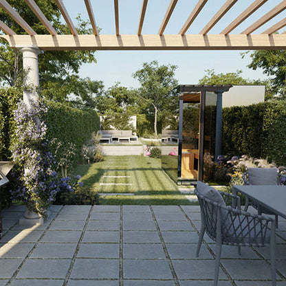 Outdoor patio area with a glass sauna, wooden pergola, chairs, and a table in a garden setting.