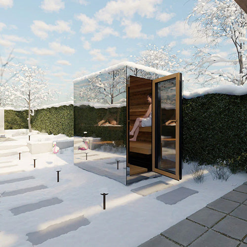 Modern outdoor sauna with mirrored walls in a snowy garden setting