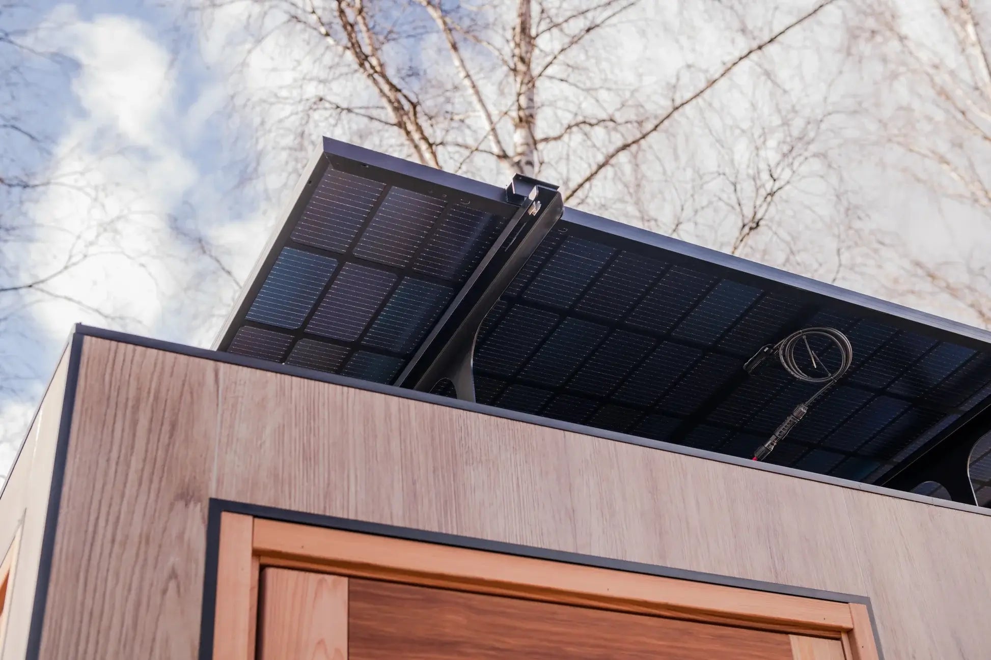 Solar panel on a sauna with trees and sky in the background