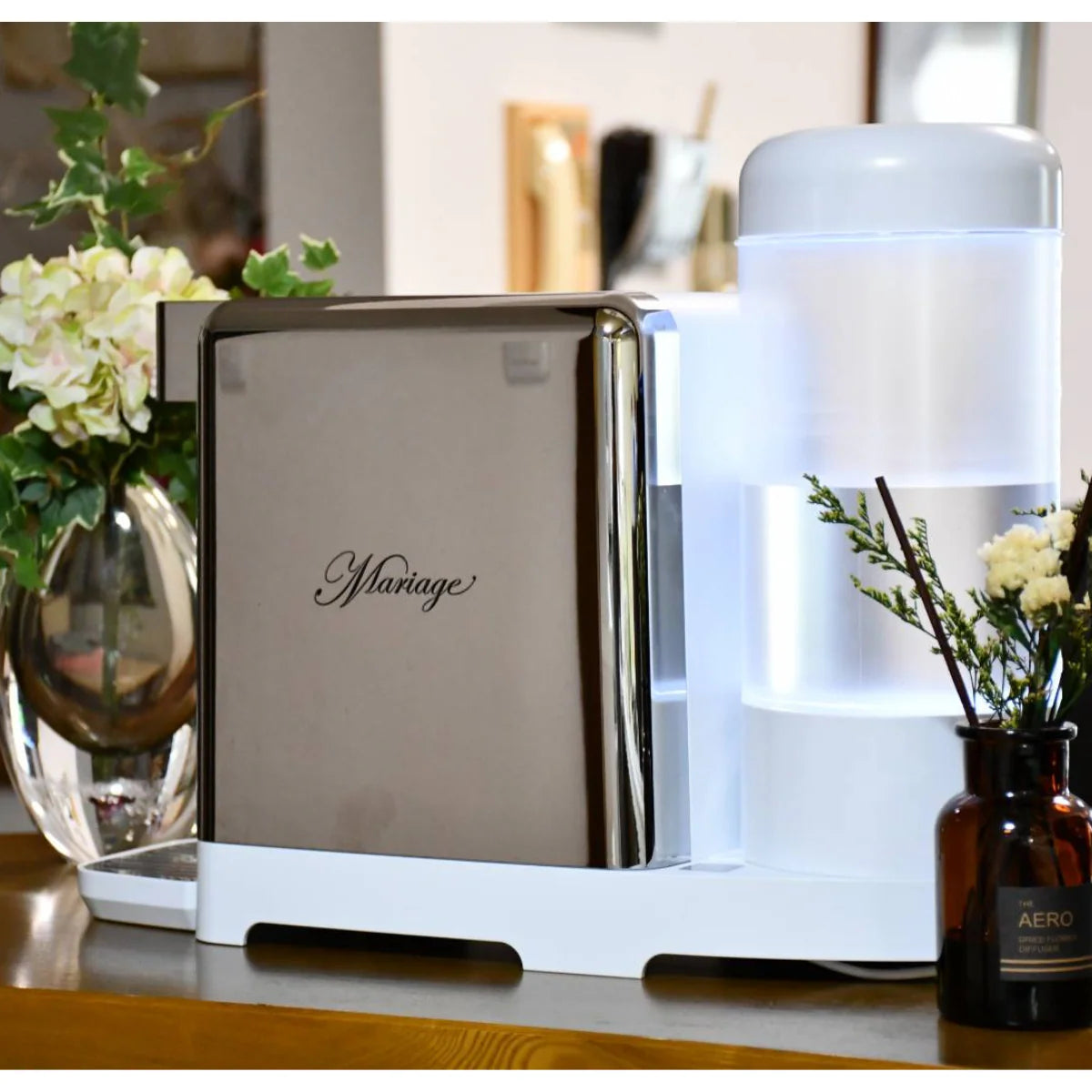 water machine with 'Mariage' on a shelf with flowers and a bottle in the background