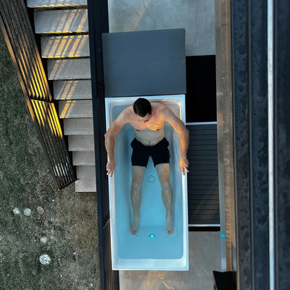 Man lying in a pool with a modern outdoor setting