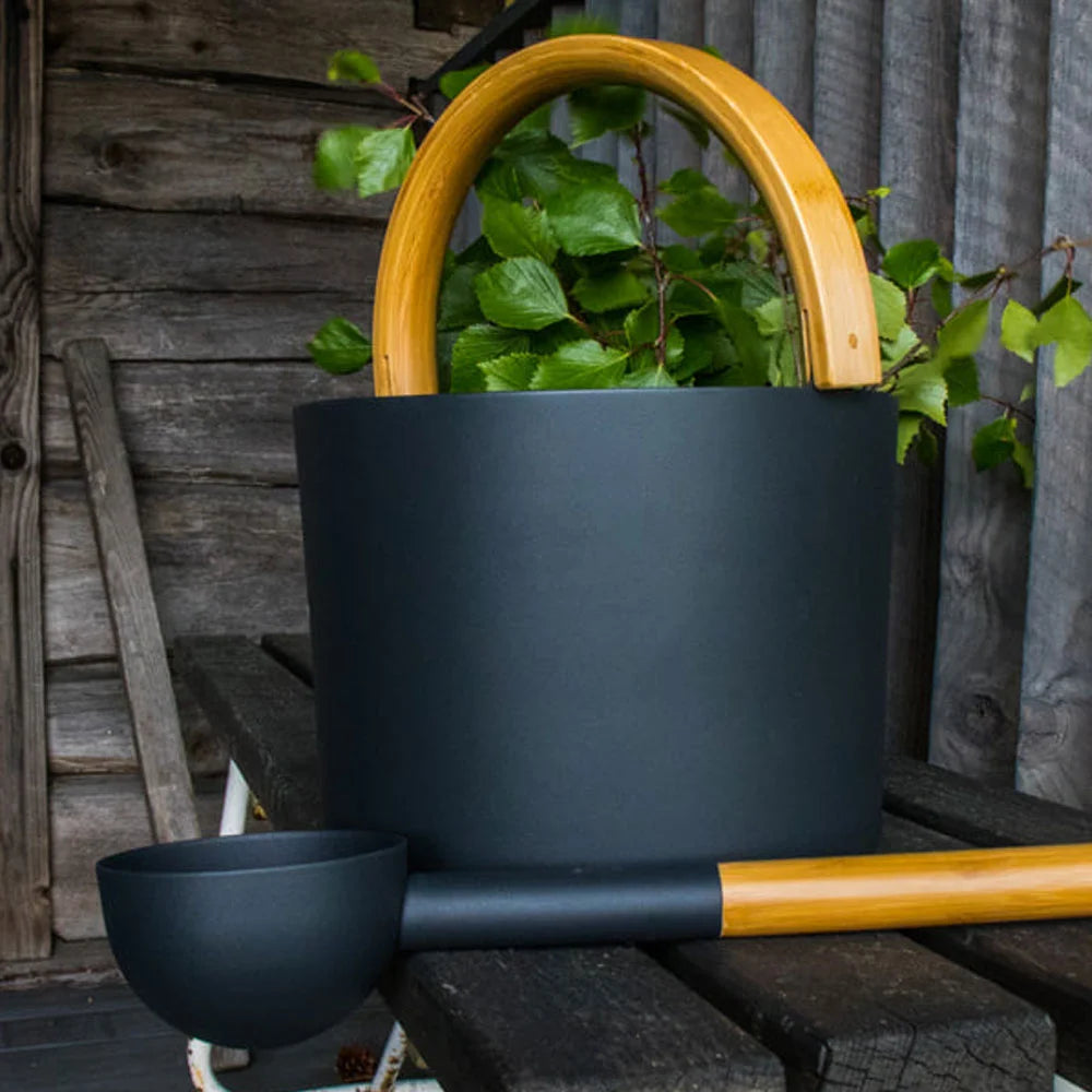 black bucket with wooden handle and ladle in a sauna