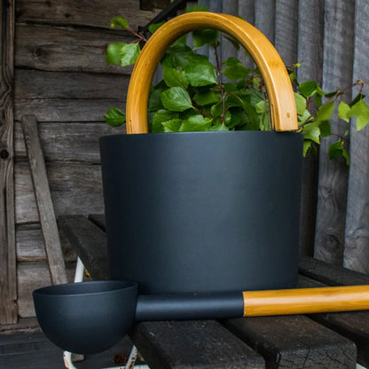black bucket with wooden handle and ladle in a sauna