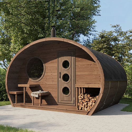 Wooden barrel-shaped sauna with a door, windows, and stacked logs in a natural setting.