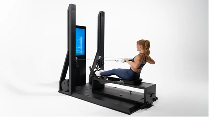 Woman using a rowing machine with a digital display on a white background