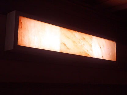 Rectangular light fixture with a warm glow on a dark background