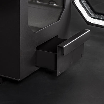 Close-up of a black ash tray drawer with metallic handle on a dark surface