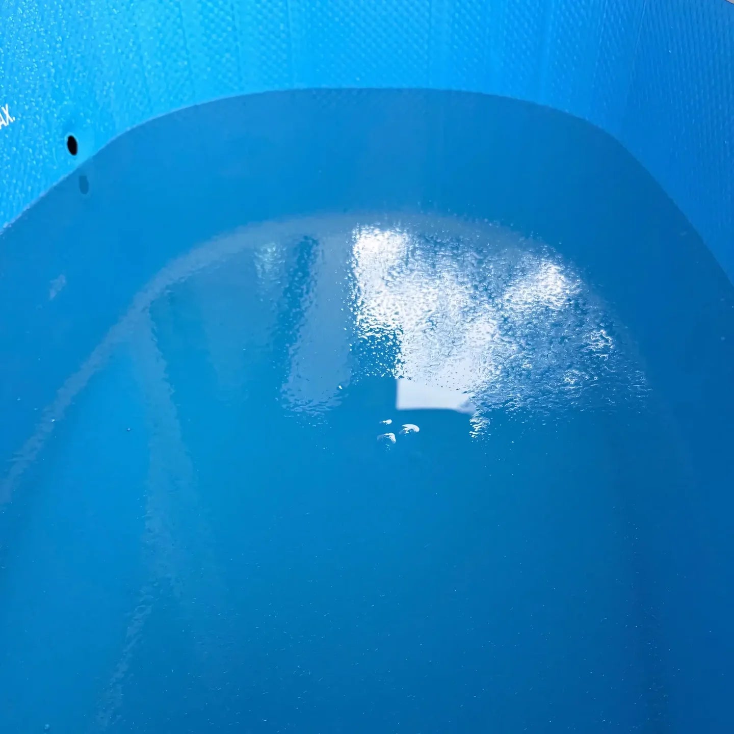 Close-up of a blue plastic container with water droplets on the surface
